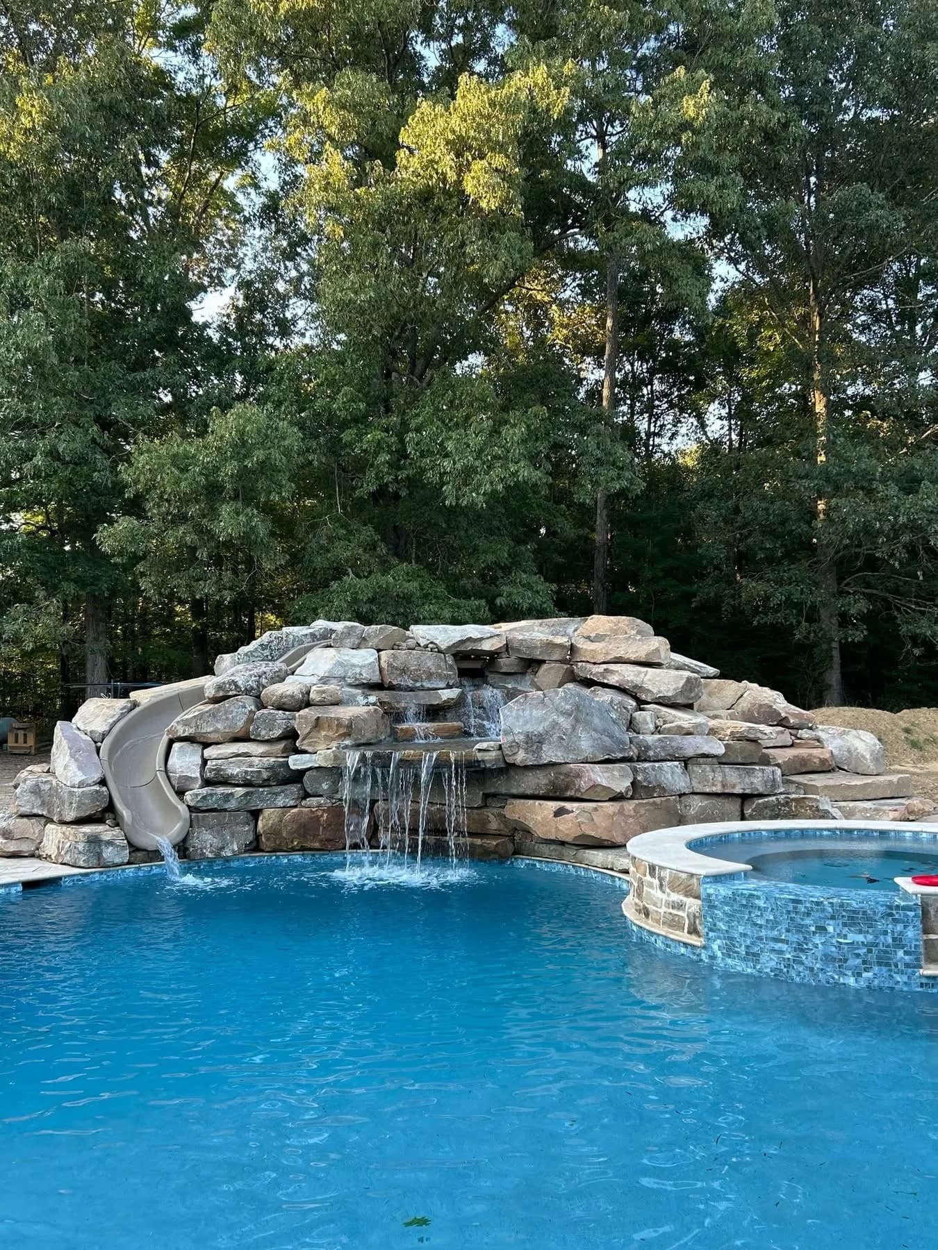 Custom Stone Waterfall Feature Built Into a Pool Area image